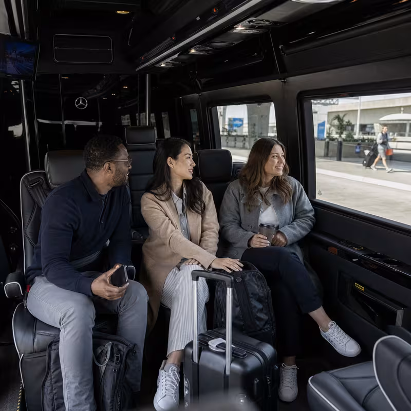 Passengers loading luggage while boarding an Phoenix group shuttle