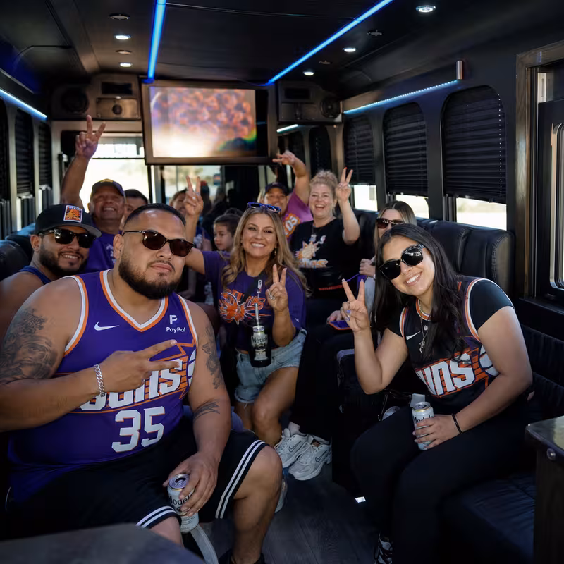 Group boarding a white charter bus for Sporting Event Transportation transportation in Phoenix